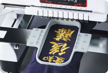 Embroidered golden letters in embroidery frame